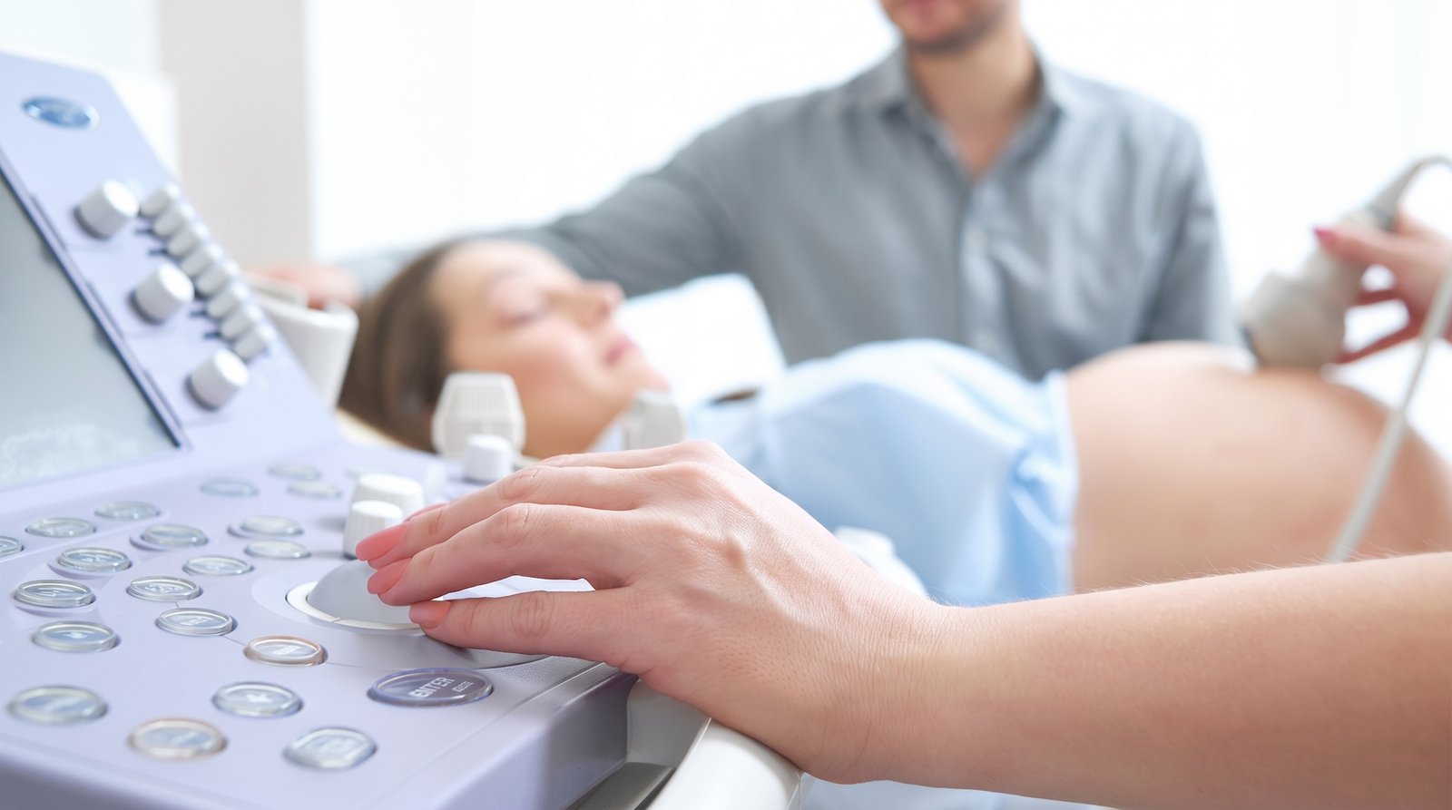 Gynecologist with patient performing ultrasound.